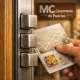 Primer plano extremo de una puerta acorazada en Barcelona, mostrando detalles del cerrojo y un folleto sobre dónde comprar.