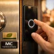 Cierre de puerta blindada moderna en Barcelona, con detalles en aluminio reciclado y mano acercándose al panel táctil.